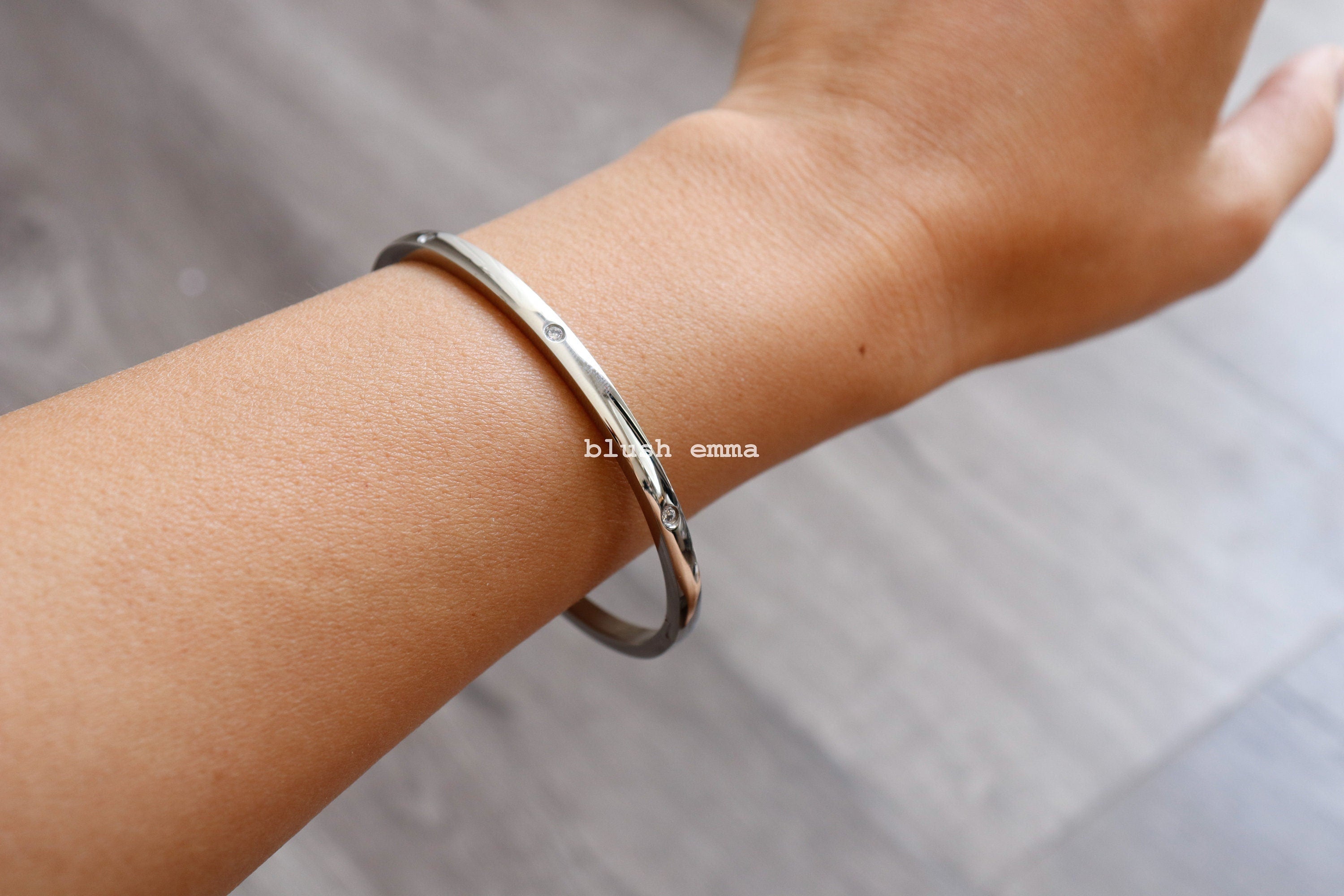 A stainless steel oval cuff bracelet with gold plating and crystal accents, worn on a person's wrist. Rounded Stainless Steel Rhinestone Paved Oval Cuff Hinge Latch Bracelet | Gold Plated | Aesthetic | Minimalist Jewelry | Best Friend Gift her