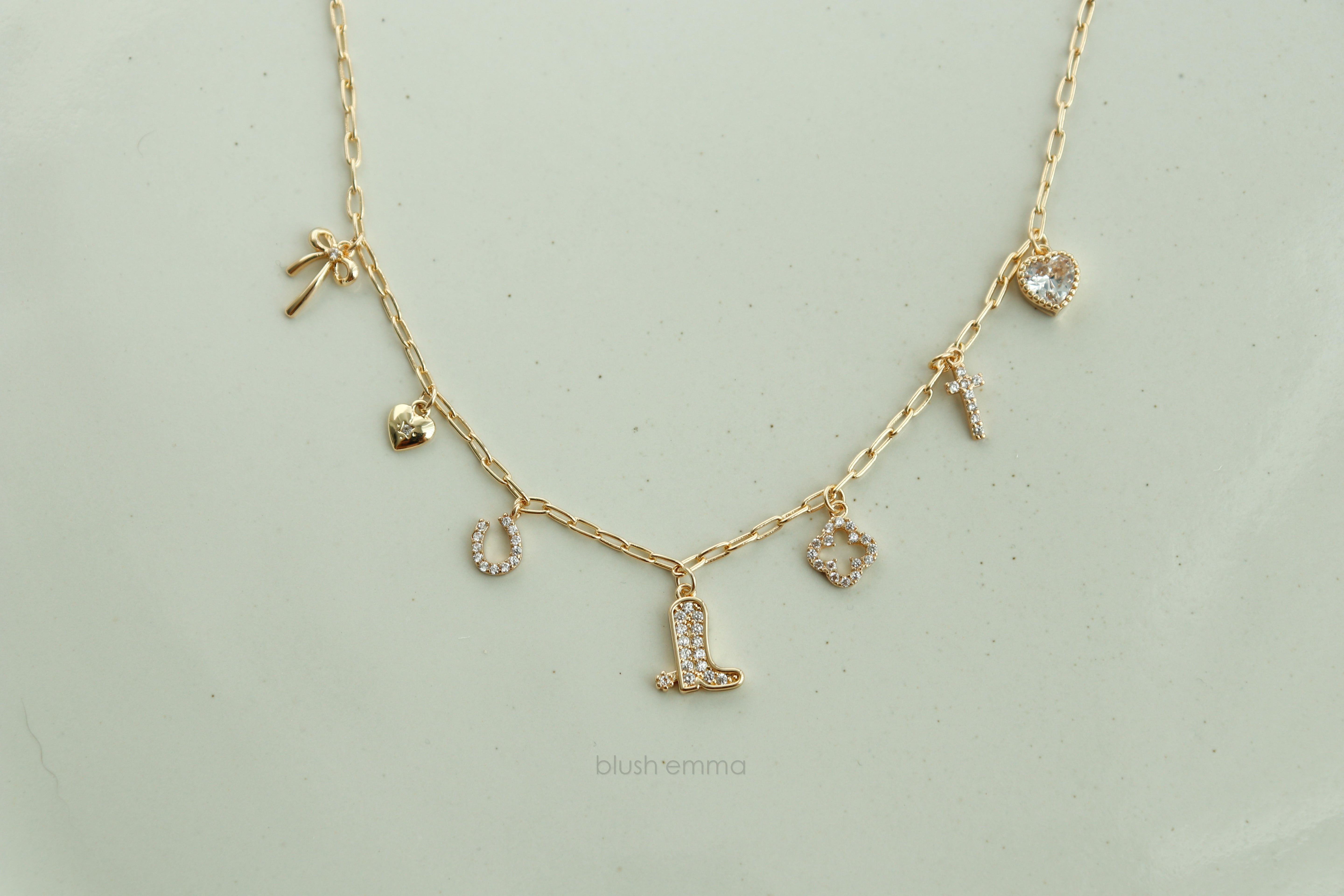 Dainty Small Sparkly Charms Station Necklace. Charms are placed on tiny paperclip chain, charms include: Ribbon, Micro Heart, Horseshoe, Boots, Clover, Cross and Crystal Heart