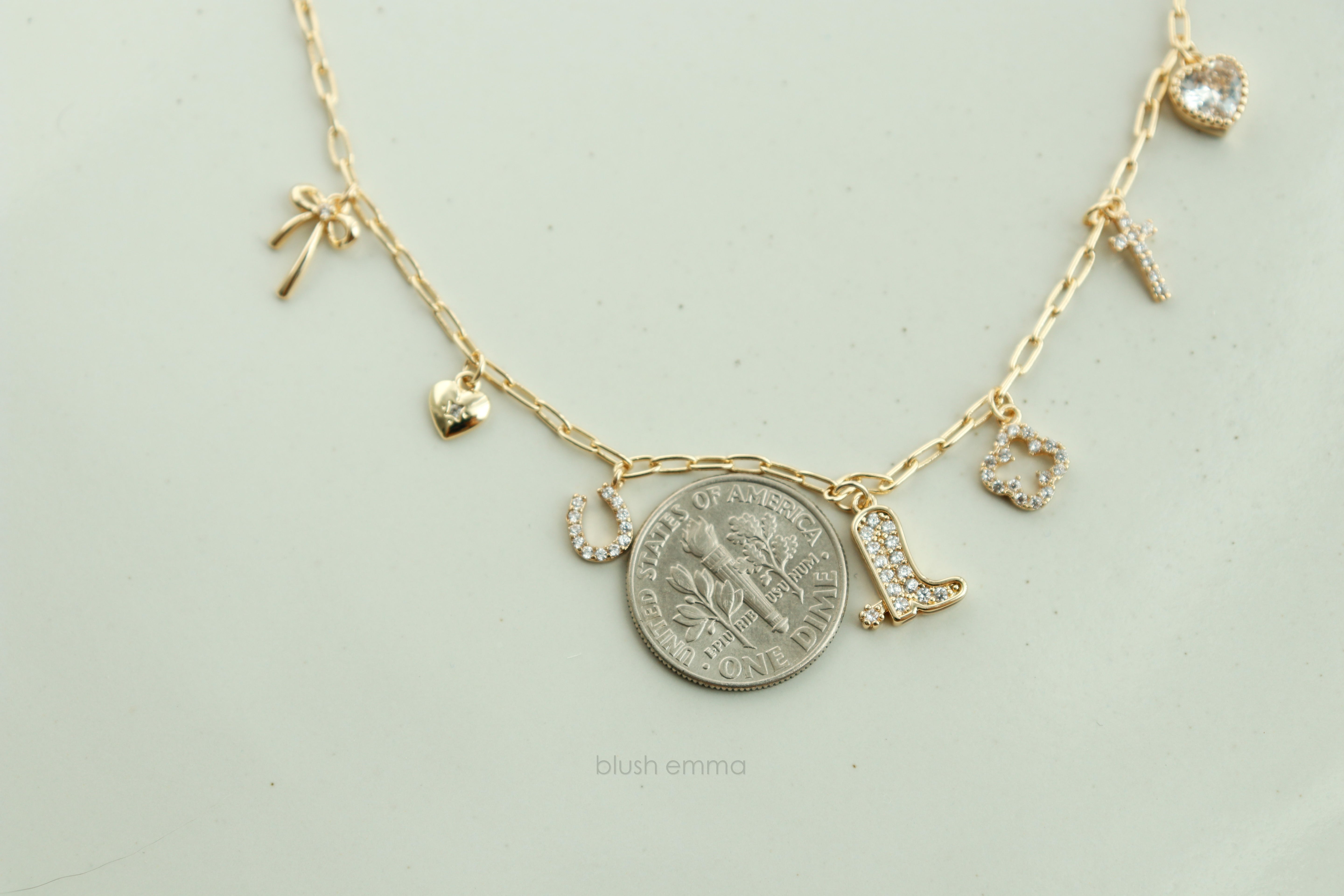 Dainty Small Sparkly Charms Station Necklace. Charms are placed on tiny paperclip chain, charms include: Ribbon, Micro Heart, Horseshoe, Boots, Clover, Cross and Crystal Heart