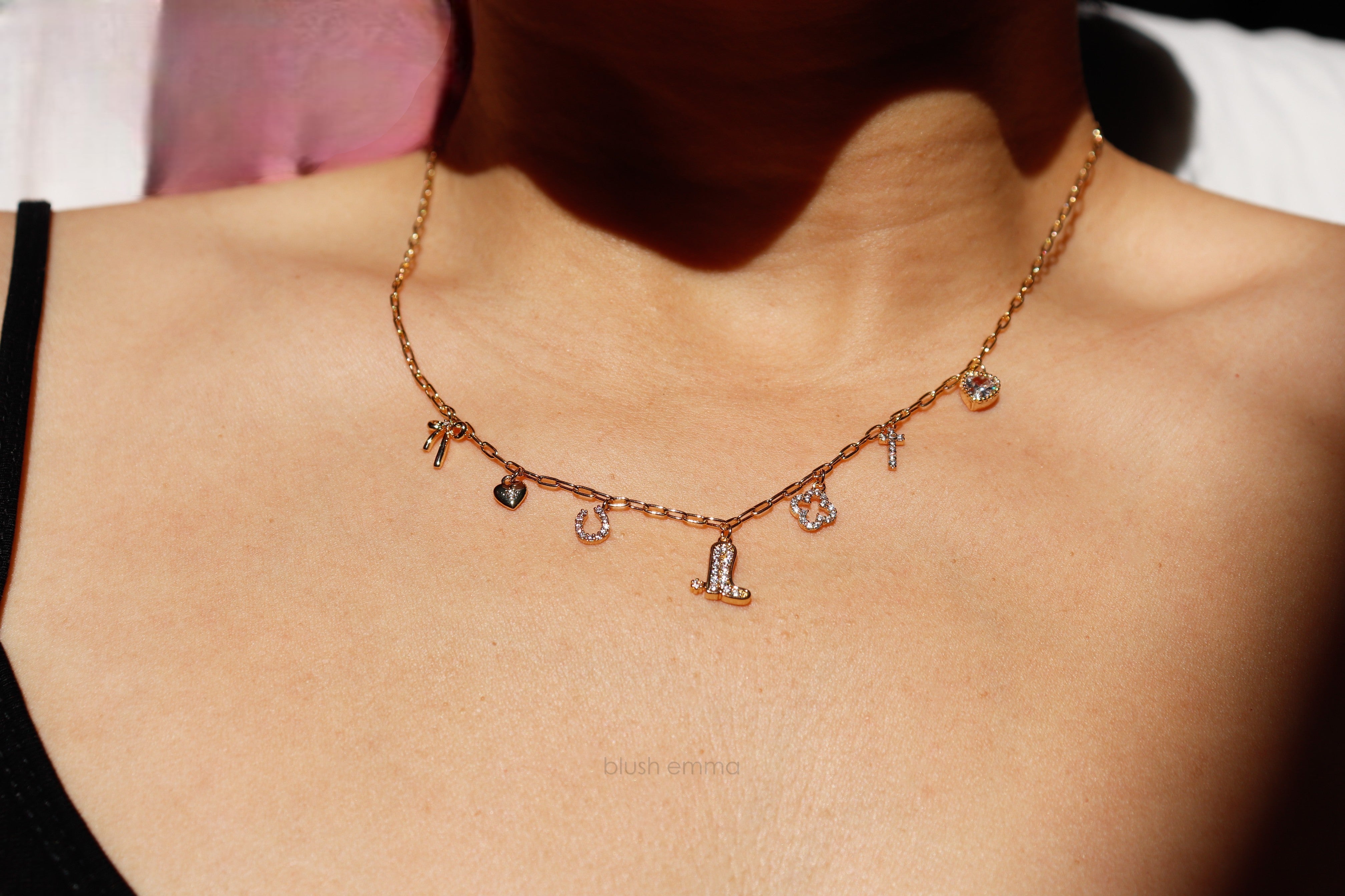 Dainty Small Sparkly Charms Station Necklace. Charms are placed on tiny paperclip chain, charms include: Ribbon, Micro Heart, Horseshoe, Boots, Clover, Cross and Crystal Heart