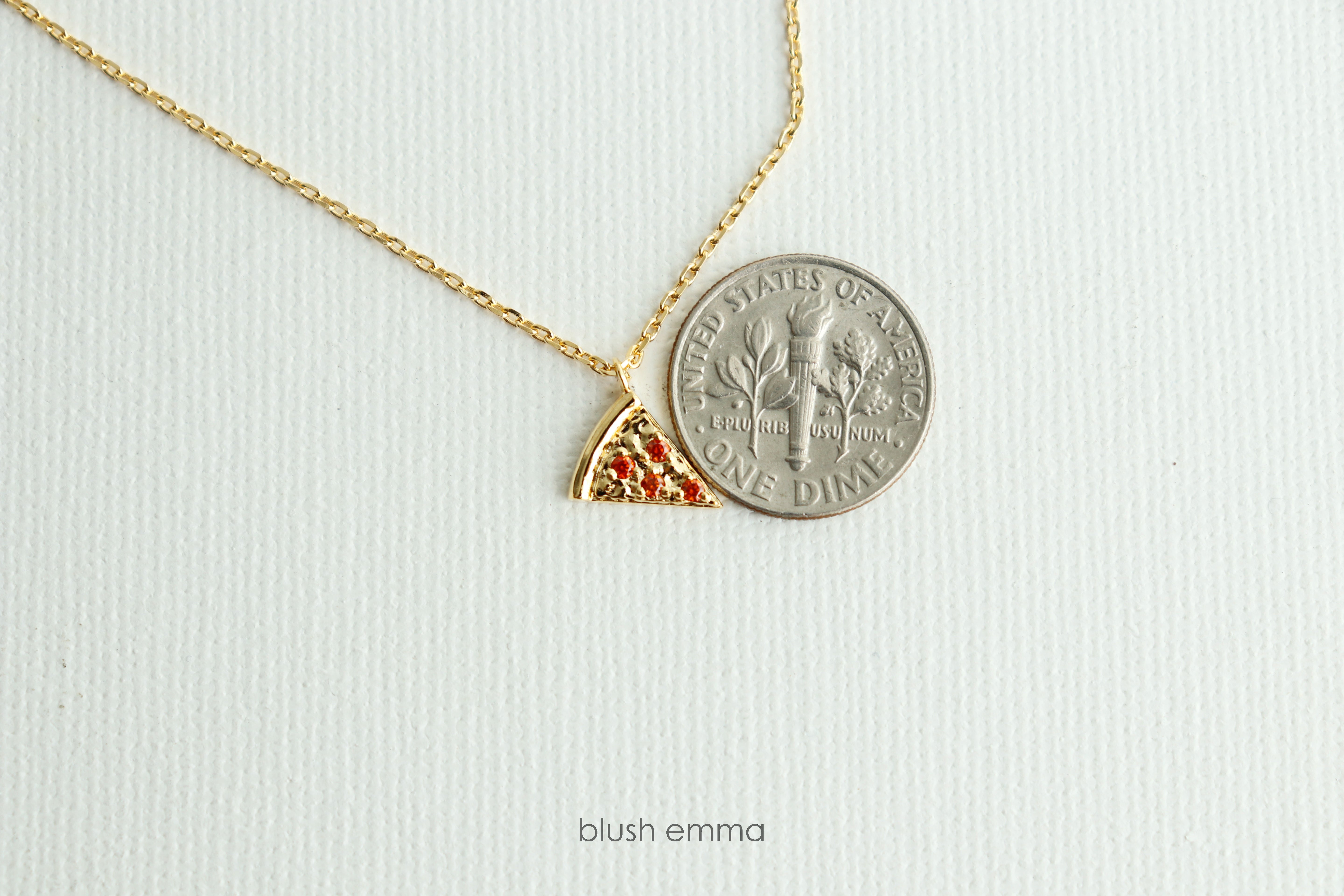 Dainty Red Cubic Pepperoni Pizza Pendant Necklace. Cute Pizza slice for layering, perfect foodie gift. Gold necklace with a pizza-shaped pendant on a light background