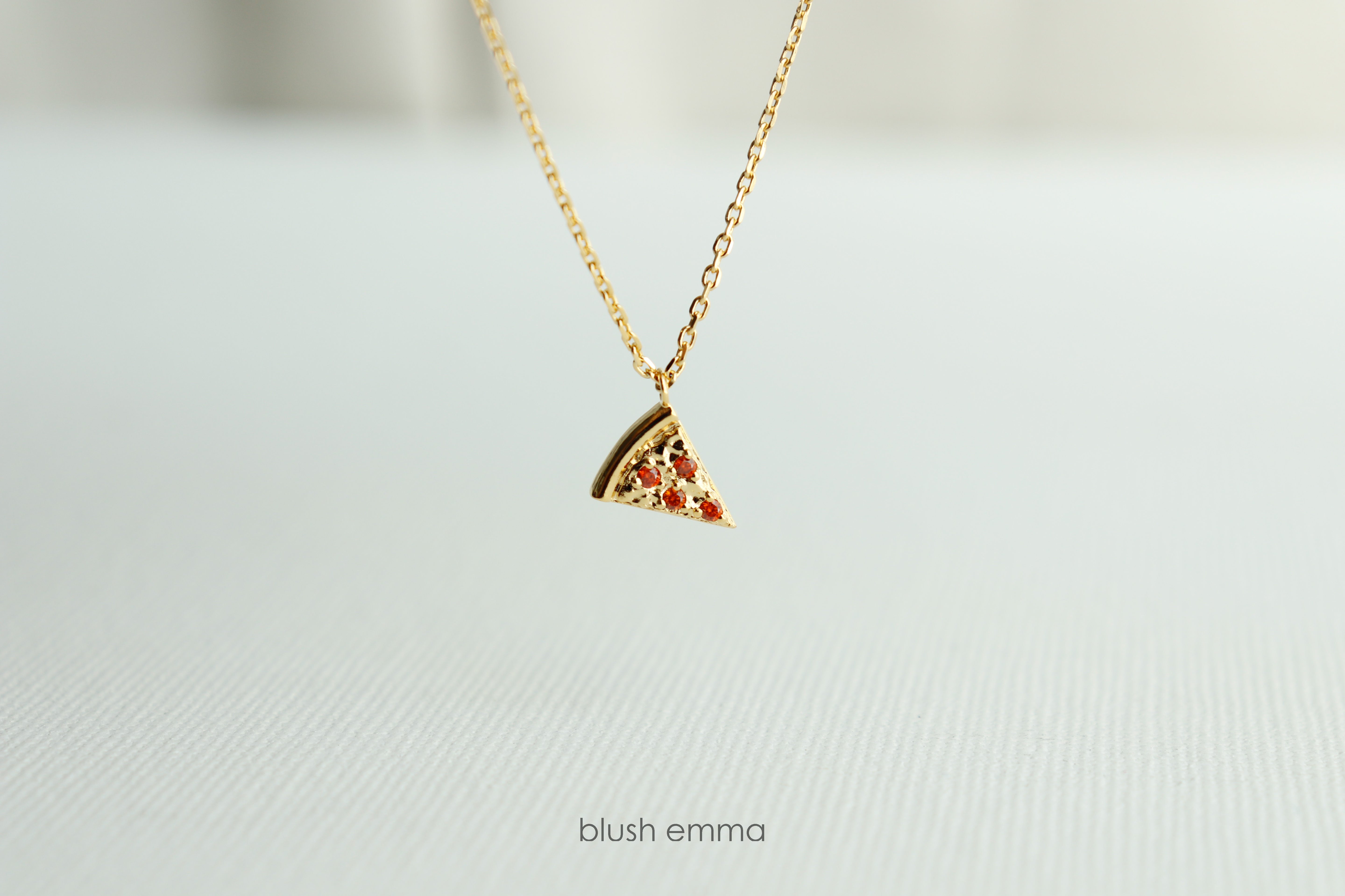 Dainty Red Cubic Pepperoni Pizza Pendant Necklace. Cute Pizza slice for layering, perfect foodie gift. Gold necklace with a pizza-shaped pendant on a light background