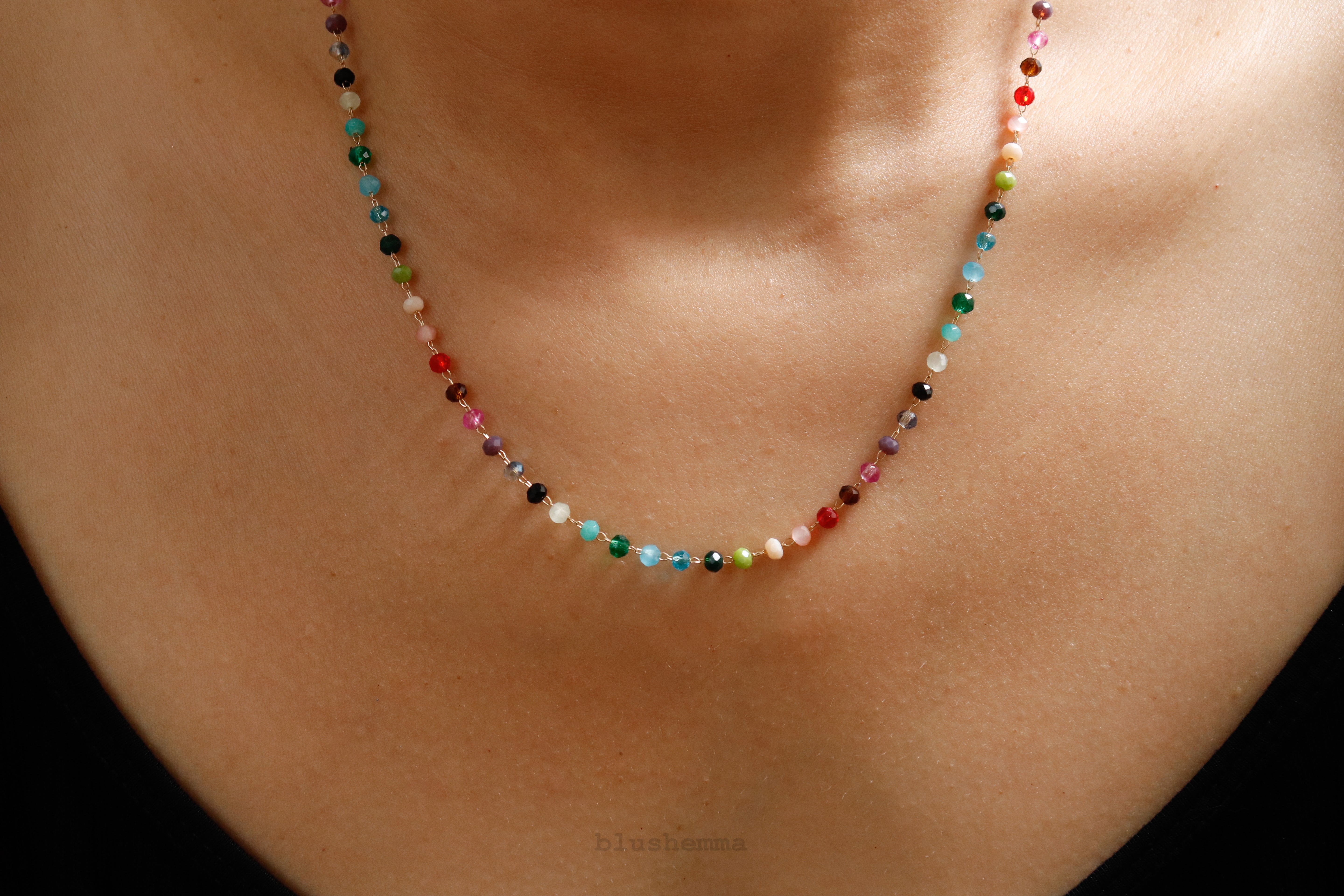 Blushemma Colorful Rainbow 3mm Crystal Glass Beaded Necklace A close-up of a person's neck wearing a delicate beaded necklace made of many small, colorful gemstone beads.
