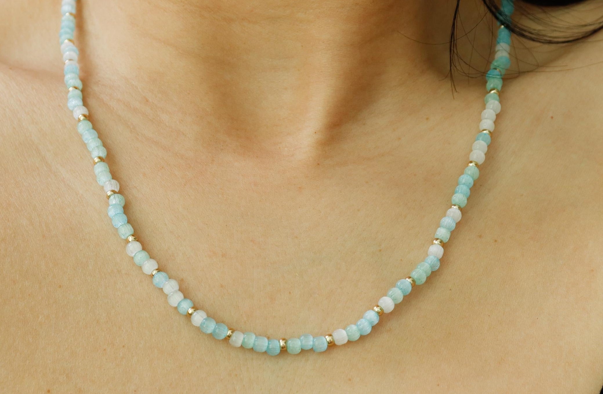 aqua Necklace with small beads worn by a person