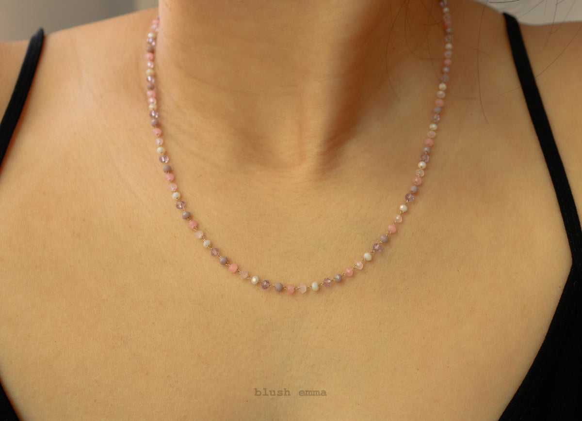 Necklace with small beads worn by a person, brand 'blush' visible